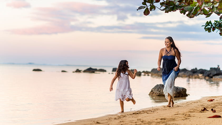 Mother and daughter playing together on a beach in Hawaii