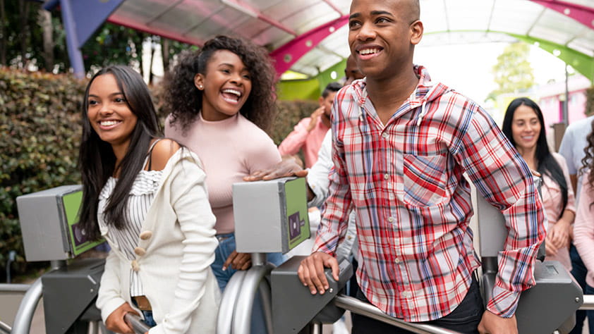 Group of young people arriving at an amusement park and looking very happy