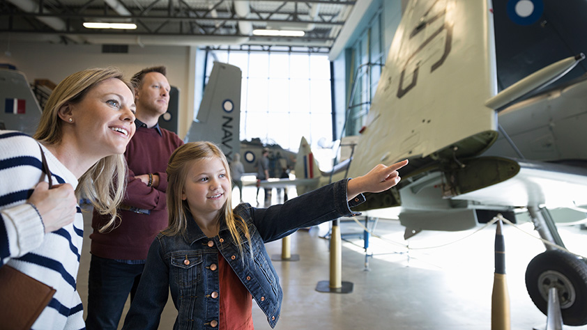 Family looking at an airplane in a museum