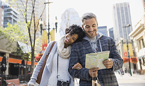 Couple Walking Through City Reviewing a Map