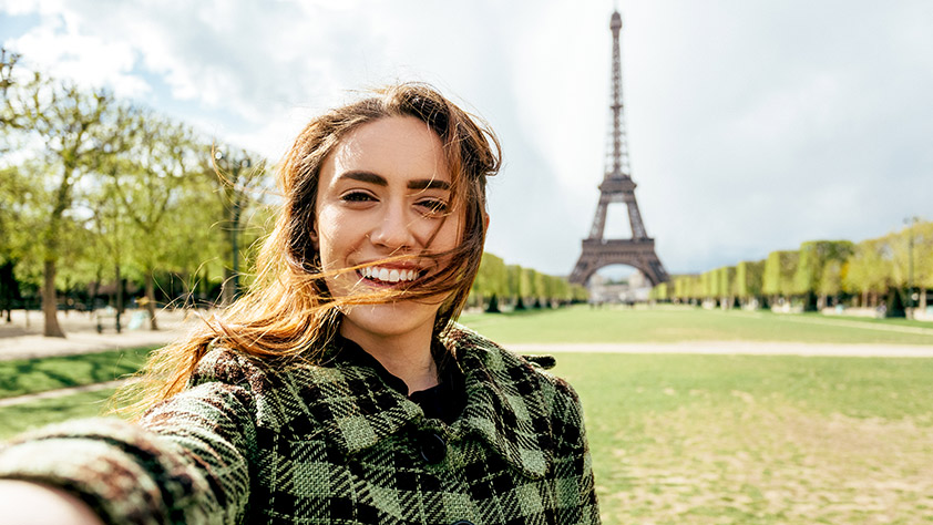 A woman taking a selfie in front of the Eiffel tower