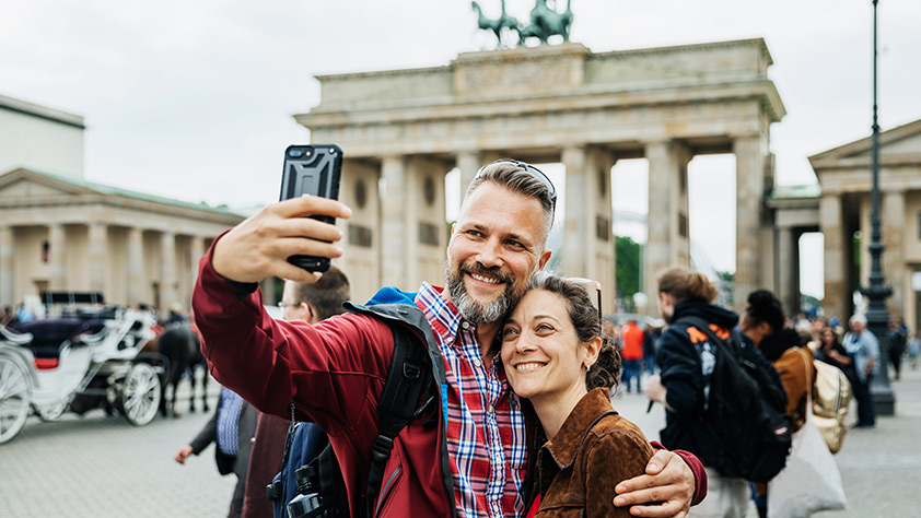 Make This the Year Your Plan Your Dream Trip - Couple Taking A Selfie Together on Front of Brandenburg Gate in Berlin