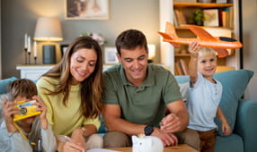 NEA member and their two children putting coins in piggy bank, saving money for future travel and preparing or their next vacation