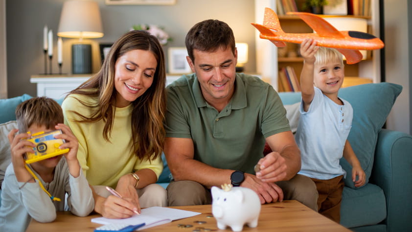 NEA member and their two children putting coins in piggy bank, saving money for future travel and preparing or their next vacation