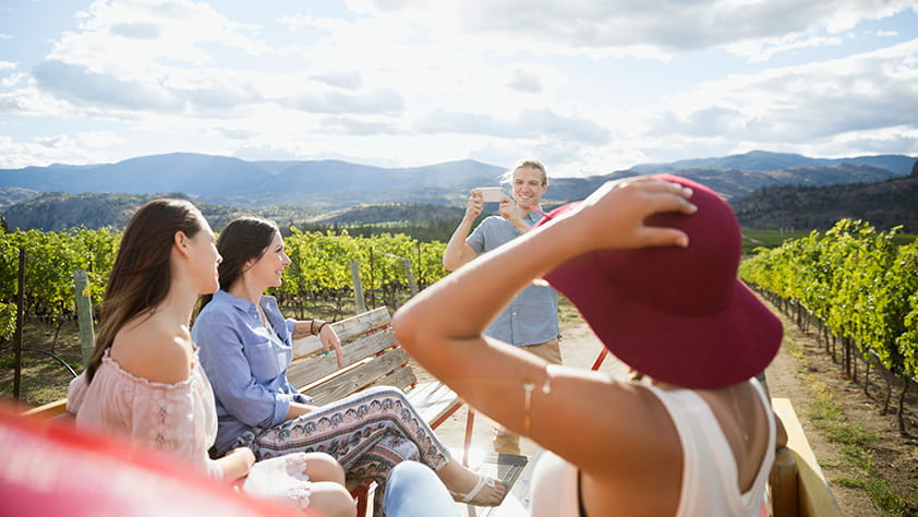Friends on Back of Truck Going Through Vineyard