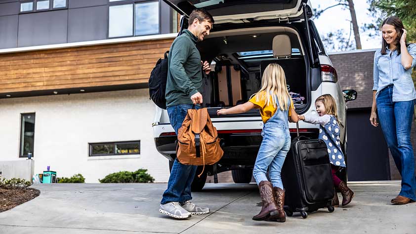 Family of NEA member packs vehicle with two young children for a vacation planned through the NEA Travel Program.