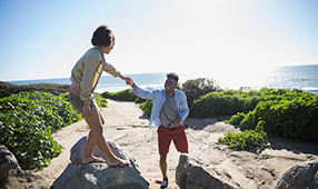 Couple Walking on Large Rocks at the Beach