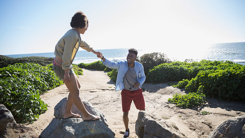 Spring Break Destinations for Grownups - Couple Walking on Large Rocks at the Beach