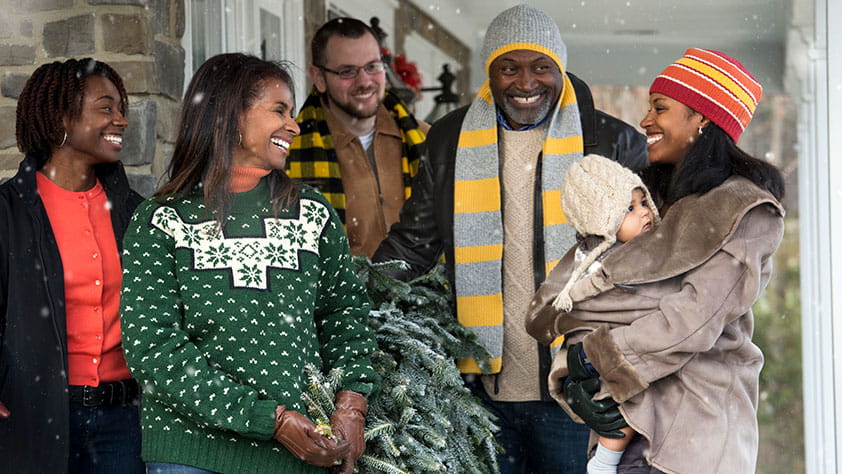 Friends smiling while it snows outside