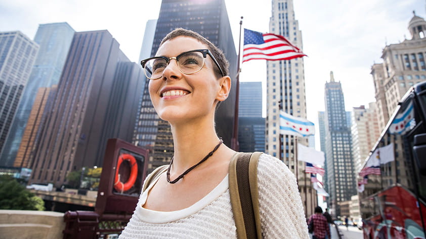 Young woman in downtown Chicago with the U.S. flag flying in the background