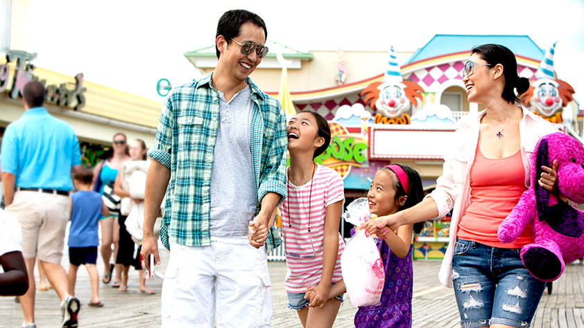 Family walking through the games section of an amusement park