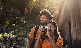 Vacationing Couple Taking Photos While Hiking in the Woods