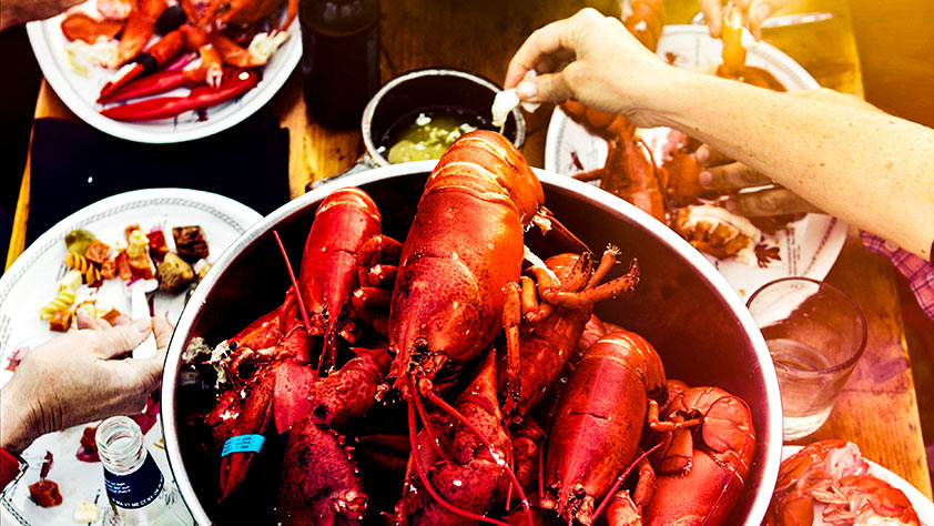 Close-up of lobsters in a pot on a picnic table