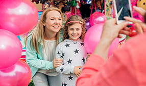 Mother Taking Photo with Daughter Holding Pink Balloons