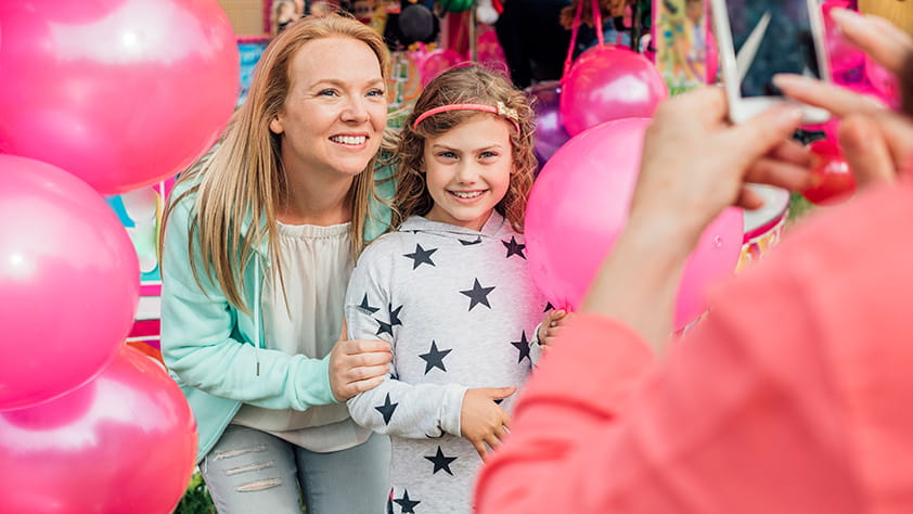 Mother Taking Photo with Daughter Holding Pink Balloons
