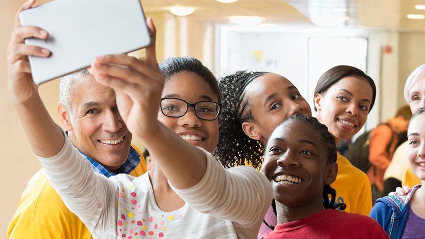 Group of older students and their teacher taking a selfie with a digital tablet