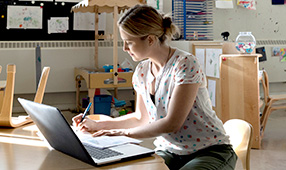 Elementary teacher working on her laptop in her classroom