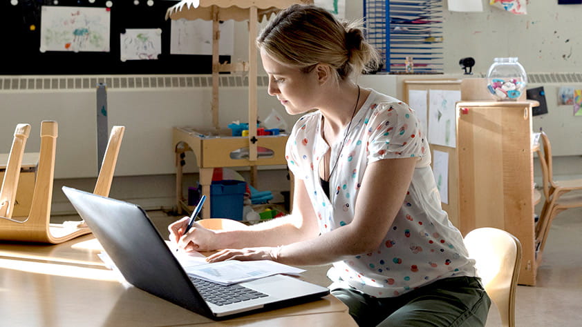 Elementary teacher working on her laptop in her classroom