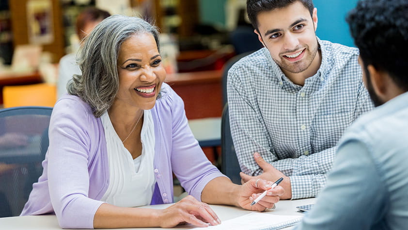 Female educator having a discussion with male colleagues