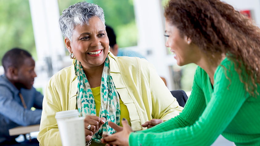 Female colleagues talking over coffee