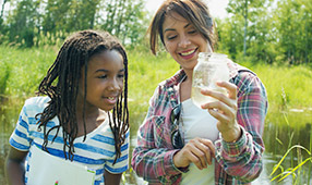 Teacher and Student Observing Science Experiment in Nature