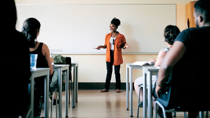 Female teacher in front of a classroom filled with parents