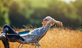 Woman relaxing with book in a sunny field