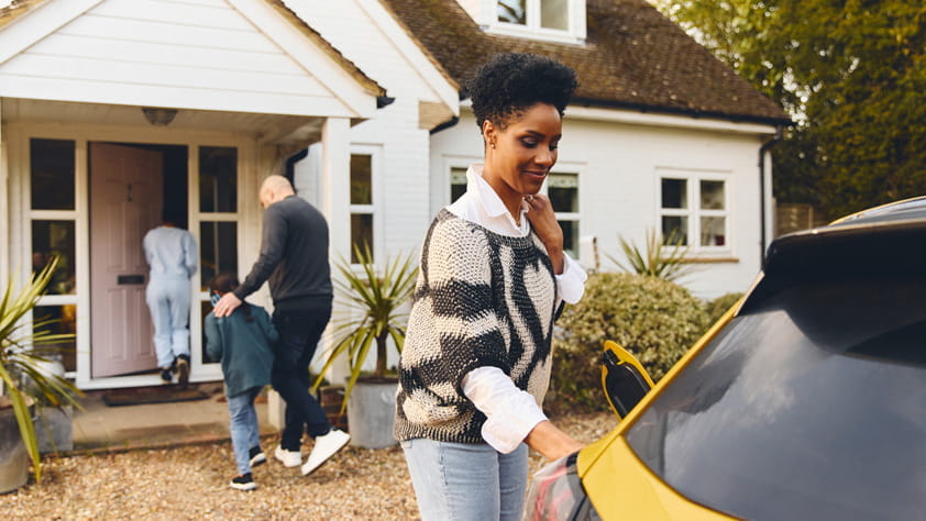 Family at home with an electric car, showing everyday life that reflects home and auto insurance needs