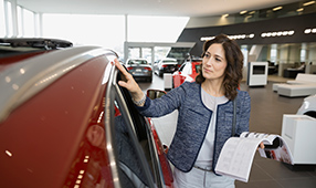 Woman Reviewing New Car at Dealership