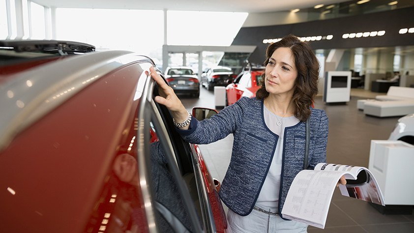 Woman Reviewing New Car at Dealership