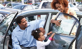 Child Reviewing Sticker Price of New Car at Dealership