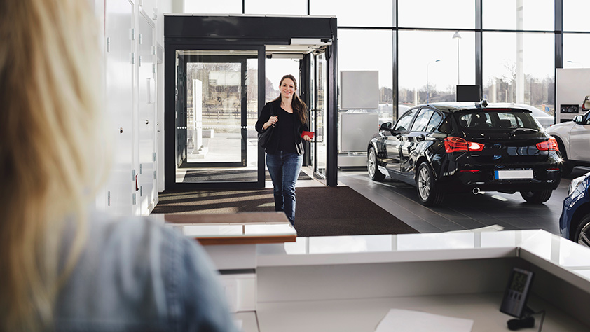 Woman Entering Auto Dealer