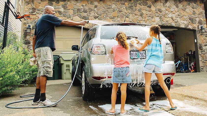 Father and Daughters Washing Car
