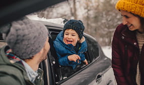 Boy Sticking His Head Outside Window on Winter Day