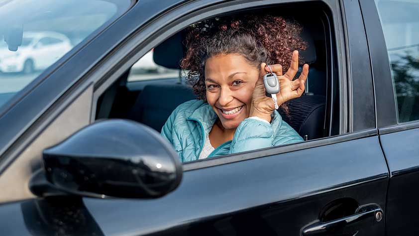 The Best Times to Buy a Car During Your Busy School Year - Smiling African-American Woman Sitting in Her New Car Showing Off Car Keys