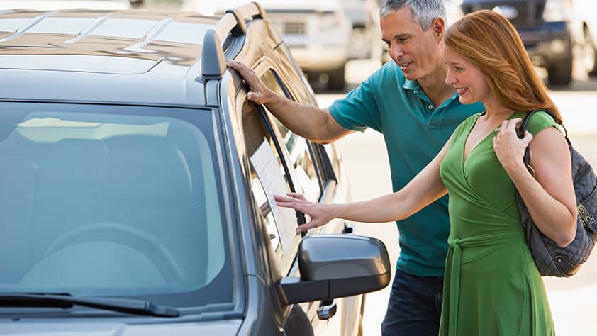 Man and Woman Looking at Car for Sale