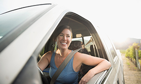 Woman Sitting in Car Smiling