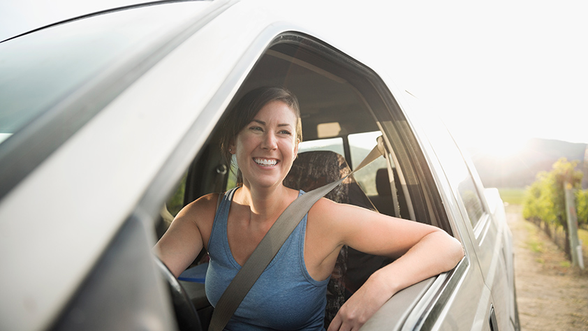 Smiley woman sitting in her car