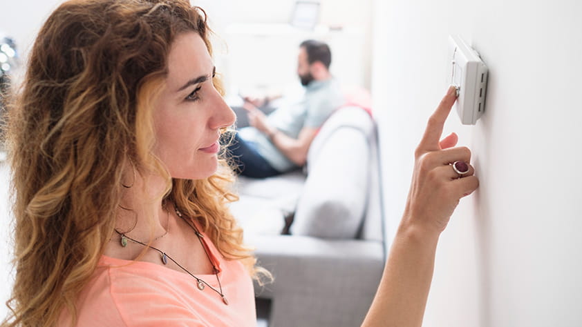 Woman Adjusting Thermostat