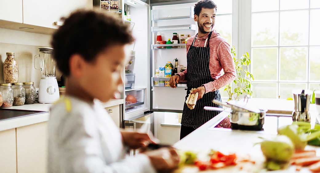 Father Smiling While He Prepares Lunch for Son at Home