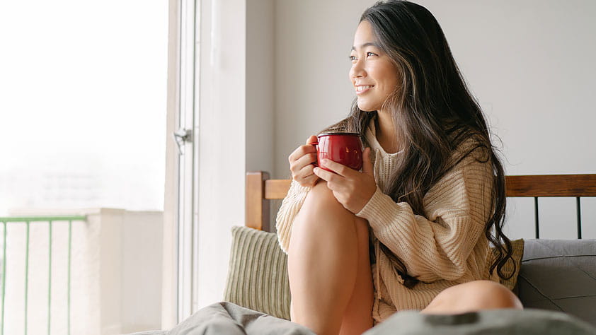 Young Woman Looking Out Apartment Window
