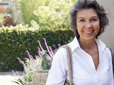 Kiplinger Retirement Report - Smiling Senior Woman Outside Home with Large Purse