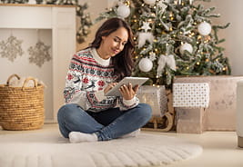 Woman Sitting on the Floor and Shopping on a Tablet