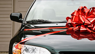 NEA Auto Buying Program - Close-Up of a Black Car with a Big Red Bow 
