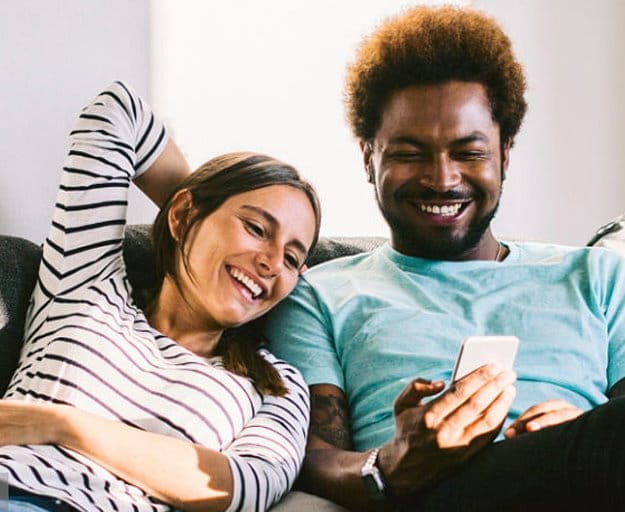 Couple on couch looking at a phone