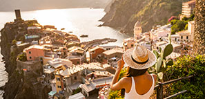 Female tourist taking a beautiful photo overlooking the landscape and water in Vernazza , Cinque Terre