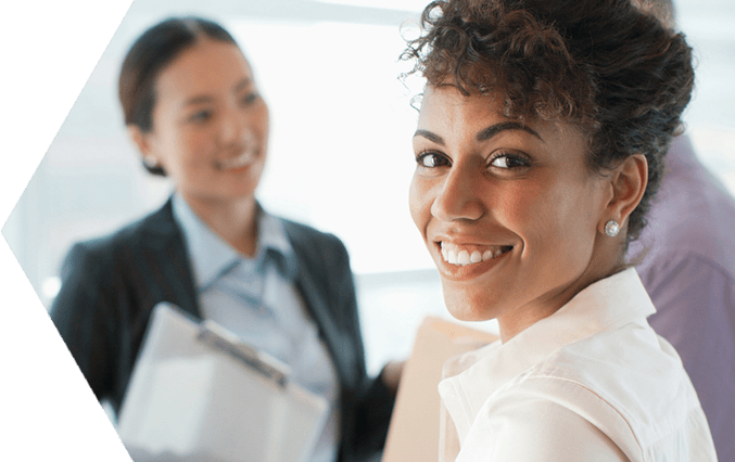 Professional woman standing in an office with colleagues