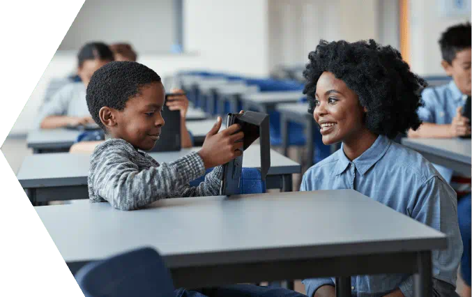 Educator kneeling down to work with young student