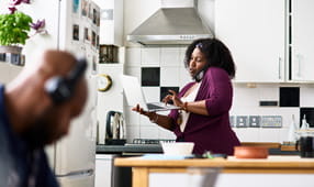 Female NEA member in her 30s on phone call and using laptop, to file an auto & home claim