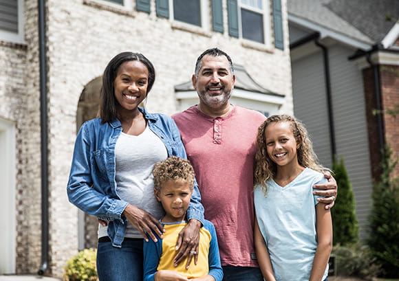 Portrait of family in front of home